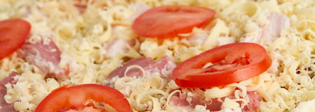 pizza with cheese, tomato and bacon before bakingの写真素材