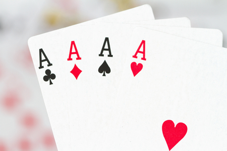 four aces against scattered, blurred cardsの写真素材