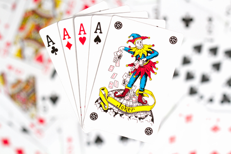 four aces and a joker on the background of scattered cards