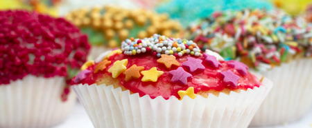 Handmade muffins decorated differently, in the foreground - colored stars and pensの写真素材