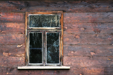 Dirty window with cracked glass in an old wooden houseの写真素材