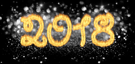 Burning inscription 2018 on a black, glossy background with stars