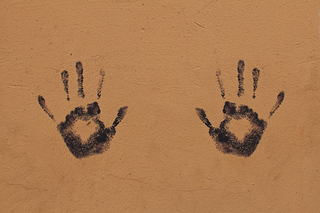 A black trace of both hands pressed on an orange wallの写真素材