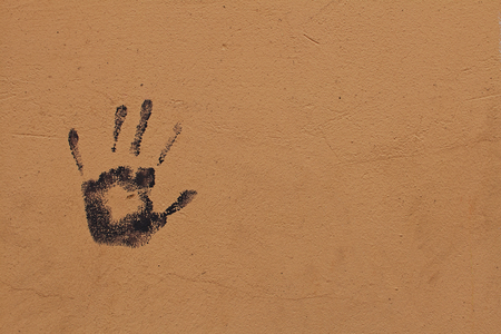 A black trace of the left hand imprinted on the orange wallの写真素材