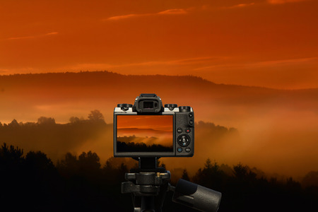 Camera and morning in the mountains - fog over the hills