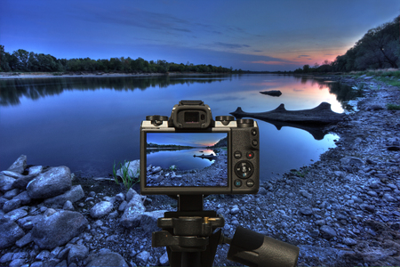 Camera and Riverbank on the sunset in the dark - blue coverの写真素材