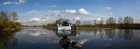 Camera and Panoramic landscape with water, blue sky with white clouds made in Poland by the Bug...