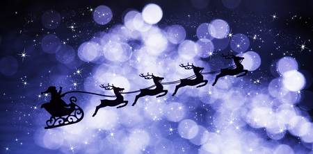 A sleigh with Santa Claus pulled by four reindeers against the background of a starry and...