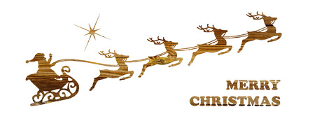 Santa's sleigh pulled by four reindeers cut from wood on a white background and Merry Christmas inscriptionの写真素材