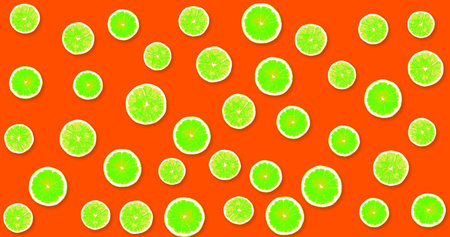 Background with green, fresh lemons on a red, strawberry backgroundの写真素材