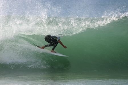 A surfer rides the barrel on a nice clean wave.