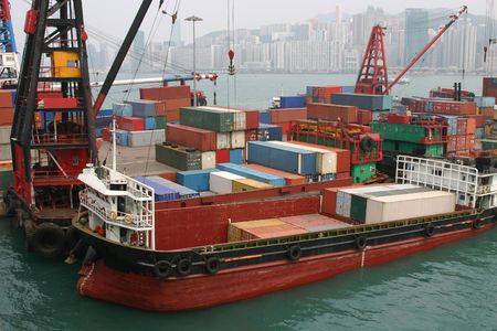 A barge being loaded with containers at a container terminal in Victoria Harbour - Hong Kong