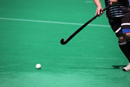 A field hockey player about to pass the ball