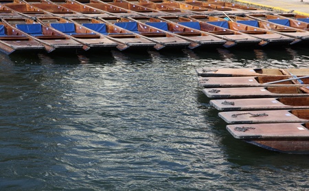 A group of wooden punts tied together on the river Cam in Cambridge - England. Punting is one of the university cities iconic activities.の写真素材