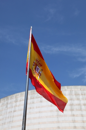 Spanish Flag vertical with building and blue sky backgroundの写真素材