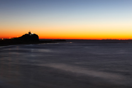 Nobbys lighthouse and beach at dawn. This headline and lighthouse is one of Newcastle most famous landmarksの写真素材