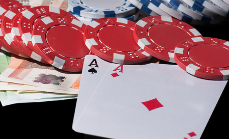 Poker cards double aces, chips and euros black background