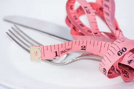 tape-measure and fork white background isolatedの写真素材