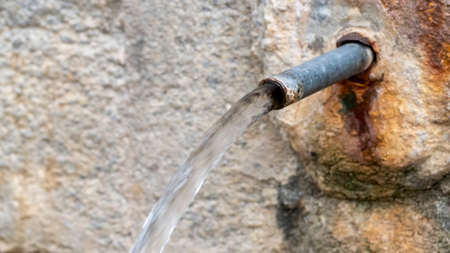 spring water flowing from an ancient natural stone spring
