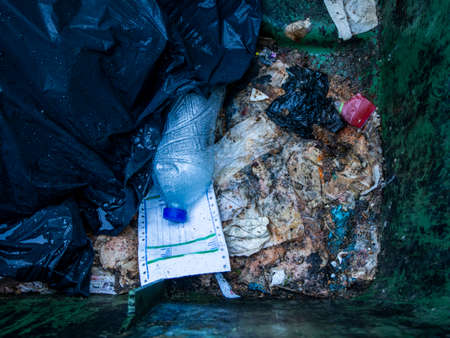 Pile of plastic bags with waste on the ground.