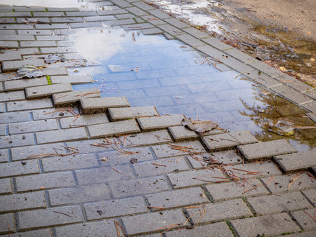 puddle in a pothole on a road after a rainstorm. Concept of risk and insecurityの写真素材