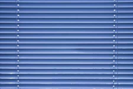 blue jalousie on the window in the roomの写真素材