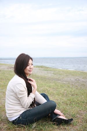 woman sitting by the seaの写真素材