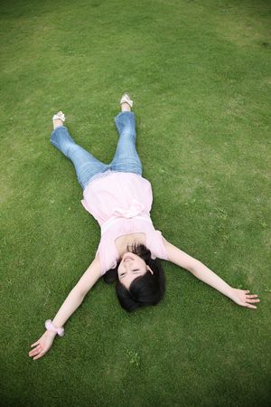 Woman lying on a lawnの写真素材