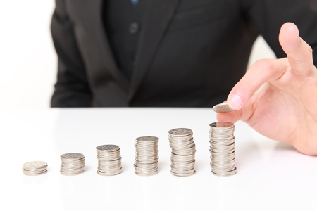 Businessman Put Coins To Stack Of Coinsの写真素材