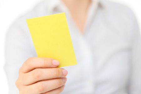 woman showing the yellow cardの写真素材