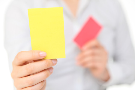 woman showing the yellow cardの写真素材