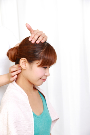 young Japanese woman getting a head massage&#12288;の写真素材