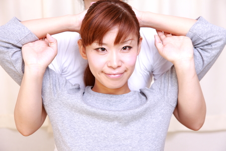 young Japanese woman getting chiropracticの写真素材