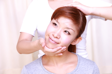 young Japanese woman getting chiropracticの写真素材