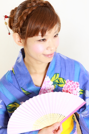 Young woman wearing Japanese kimono with paper Fanの写真素材