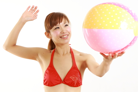 young Japanese woman wearing bikini with beach ballの写真素材