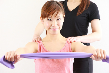 young Japanese woman doing stretch bands exerciseの写真素材