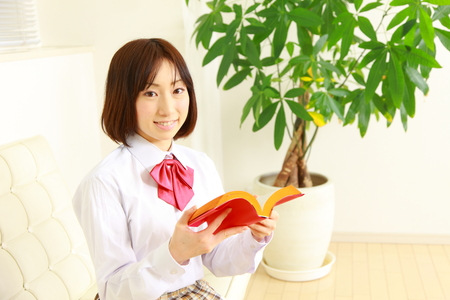 female high-school student with a bookの写真素材