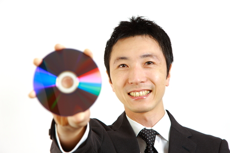 Japanese businessman showing a media discの写真素材
