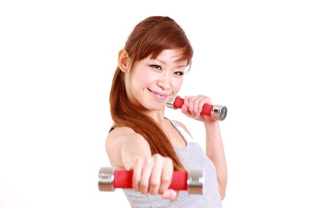 young Japanese woman with dumbbell exercisesの写真素材