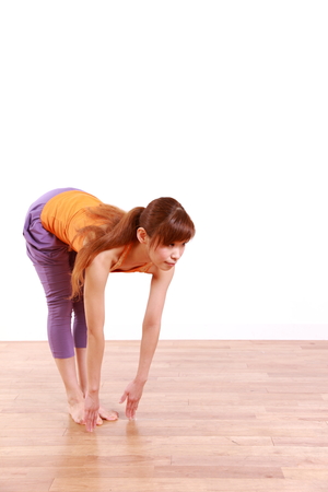 Young Japanese Woman Doing YOGA standing forward bend pose の写真素材