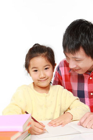 father helping his daugther doing homeworkの写真素材