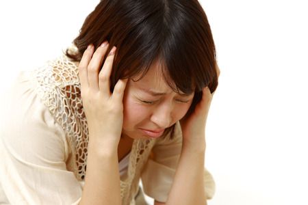 Frustrated young businesswoman pulling her hairの写真素材