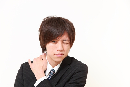 young Japanese businessman suffers from neck acheの写真素材