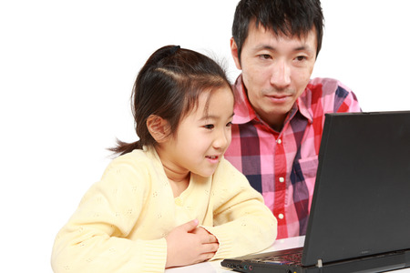 Japanese father and daughter on laptop computerの写真素材