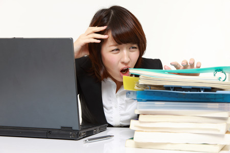 businesswoman shrinks from overtime workの写真素材