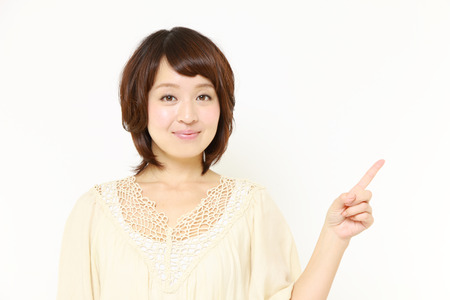 Japanese woman presenting and showing somethingの写真素材