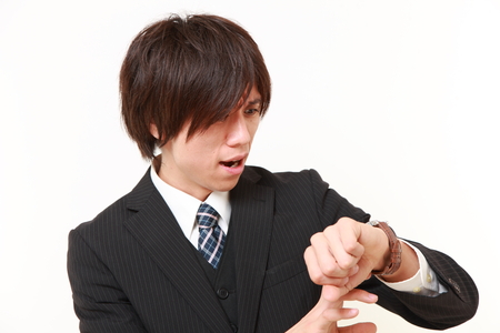 worried businessman looking at the wachの写真素材