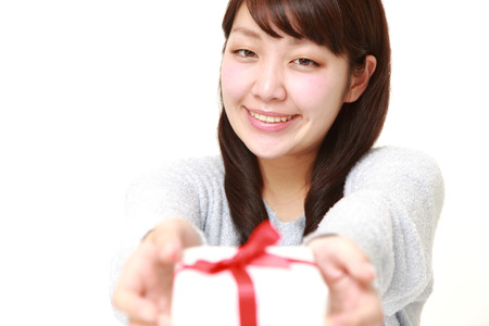 young Japanese woman offering a giftの写真素材