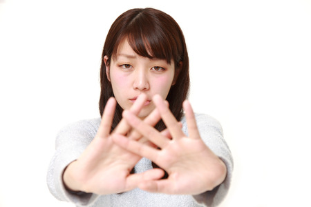 portrait of young Japanese woman making stop gestureの写真素材